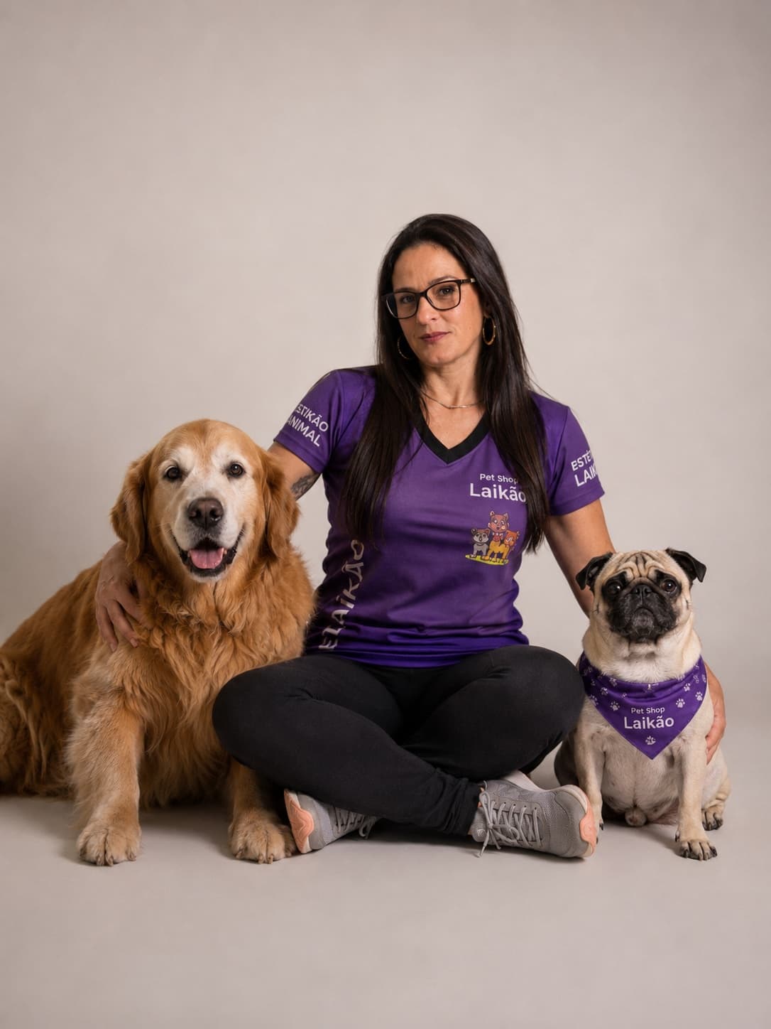 Cris, da Pet Shop Laikão, com um golden retriever e um pug